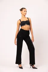Pantalón de jean negro de tiro alto y corte wide leg, con apliques de strass negros en la parte frontal.