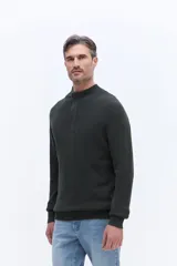 Buzo de tejido acanalado con cuello alto y apertura frontal con cierre, de calce cómodo y estructura limpia.