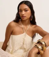 Vestido midi de encaje color crudo, con escote strapless, superposición en el busto, falda asimétrica y forro interno.