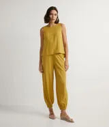 Pantalón harem color mostaza, con cintura elástica ancha, pliegues delanteros y horizontales, barra ajustada con elástico y pliegues.