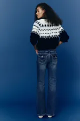 Jean de denim azul con leve stretch, corte ajustado de cintura a cadera y acampanado desde la rodilla al bajo. Modelo de tiro bajo con cierre y botón, bolsillos delanteros abiertos y bolsillos traseros con solapa y botón.