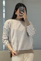 Buzo de tejido de punto con diseño de rayas horizontales en color fucsia y blanco, cuello redondo, mangas largas con puños anchos y ruedo con abertura lateral.