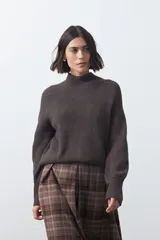 Polera de tejido de punto en color marrón oscuro, con cuello alto y diseño de silueta relajada.