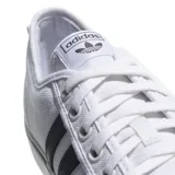 Championes Adidas modelo Nizza, de lona blanca con las tres tiras laterales en negro y suela de goma vulcanizada con detalle de línea negra.
