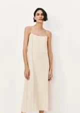 Vestido largo color beige con breteles finos y corte recto.