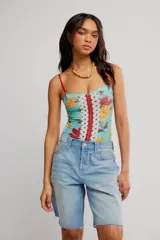 Body ajustado de nylon con estampado floral y paneles combinados de encaje y tul con lunares, tiras finas rojas y cierre frontal con cremallera.