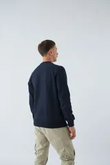 Buzo blanco de algodón con cuello redondo, mangas largas y logo y arte en relieve en el frente.