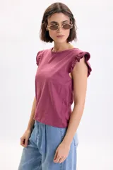 Camiseta sin mangas color bordó con detalle de volados en los hombros y cuello redondo.