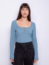 Top de manga larga ceñido al cuerpo, color negro, con escote bote pronunciado y detalle de botones forrados en el centro del pecho.