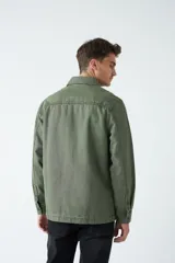 Sobrecamisa verde militar de algodón grueso tipo canvas, con cuello clásico, cierre frontal con botones, dos bolsillos de parche en el pecho con solapa abotonada y dos bolsillos de parche en la parte inferior.