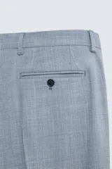 Pantalón de vestir corte slim fit, confeccionado en tejido con lana, con bolsillos frontales y traseros de doble vivo con botón.