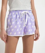 Short de pijama tipo runner confeccionado en viscosa, color lila con estampa de corazones blancos. Posee cintura elástica con cordón de ajuste blanco y ribetes en contraste en el ruedo.