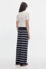 Pantalón de punto negro con rayas horizontales blancas, de calce recto y cintura elastizada.