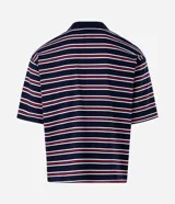 Remera polo de algodón con diseño a rayas horizontales en azul marino, rojo y blanco, corte boxy amplio, mangas cortas y cuello polo con botones. Presenta un pequeño bordado en el pecho.