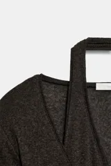 Top de punto efecto doble color gris melange, con diseño de cuello en pico, tirantes tipo halter interiores y cierre frontal con botones. Cuenta con mangas largas.