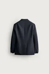 Blazer regular fit de lana color negro, con cuello de solapas de muesca, manga larga con botones en los puños y cierre frontal de botonadura. Cuenta con bolsillos de vivo en el pecho y de solapa en la cadera. Colección especial Aaron Levine x Zara.