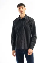 Camisa de manga larga color azul marino, confeccionada en algodón, con cuello abotonado (button-down) y un pequeño logo bordado en el pecho.