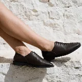 Zapato de cuero color marrón oscuro, con cordones frontales y suela de goma.