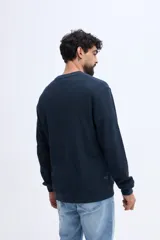 Buzo de algodón texturizado color azul marino, de cuello redondo, manga larga y calce clásico.