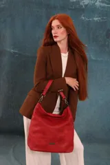 Cartera tipo bandolera de gran tamaño, confeccionada en cuero sintético con acabado desgastado. Cuenta con una asa corta fija, una correa larga regulable y extraíble, y una placa metálica con la marca en la parte frontal.