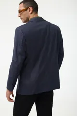 Blazer azul marino con estampado a cuadros, de corte clásico, con solapas de muesca, cierre de dos botones y bolsillos delanteros con solapa.