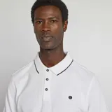 Chomba blanca de piqué de algodón, manga corta, con cuello clásico y tapeta de botones.