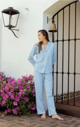 Pijama celeste de algodón, compuesto por una camisa de manga larga con botones y un pantalón recto con elástico en la cintura.