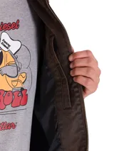 Chaqueta de estilo chore en tejido de sarga encerada color marrón, con cierre frontal metálico, cuello camisero y bolsillo con cierre en el pecho. Presenta un diseño de corte clásico con forro interno estampado.