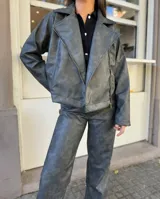 Chaqueta gris con cierre frontal y cuello solapa.