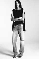 Body negro de cuello barco y tirantes con aplicación de lazos a tono. Cierre en bajo con botones a presión y en espalda con cremallera.