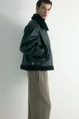 Pantalón de corte relajado y pierna recta, confeccionado en tejido suave de color marrón. Presenta cintura elástica con cordón de ajuste, pliegues frontales y traseros, bolsillos laterales y un bolsillo posterior insertado.