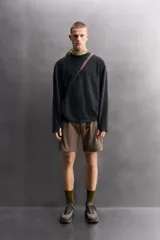 Sudadera de ajuste regular, color verde oliva, con cuello redondo y manga larga. Presenta una textura irregular en el tejido, similar al borreguito o bouclé.