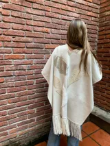 Ruana color crema de tejido de punto fino en lana con detalles en cuero y flecos.