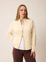 Cardigan de punto color crema con cierre frontal bidireccional, cuello alto y mangas largas con puños acanalados.