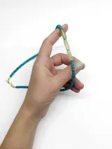 Collar de piedras naturales en tonos turquesa y verde, con cierre metálico dorado y cuentas cilíndricas centrales.