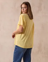 Remera blanca de lino con mangas cortas y fruncido en los hombros.