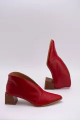 Botines de cuero color beige con diseño de tajo frontal, punta fina y taco cuadrado de madera.