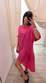 Vestido celeste de lino con corte asimétrico, más corto adelante que atrás, y diseño holgado.