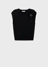 Chaleco de punto fino color negro, con cuello redondo y detalle metálico en el hombro. Diseño recto y sin mangas.