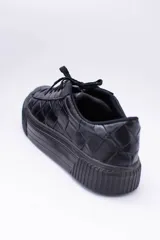 Zapatillas bajas color dorado con diseño trenzado, cordones y suela de goma.