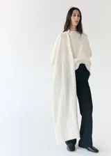 Chaleco largo de punto color blanco marfil, con diseño abierto y superpuesto de estilo versátil.