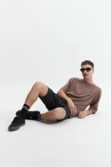 Remera gris oscuro con efecto gastado, corte boxy, manga corta y cuello redondo. Estampado en el frente con diseño abstracto y texto 'mistral'.