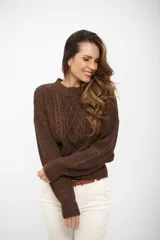 Sweater de punto con cuello redondo, diseño de trenzas frontales y acabado con hilo metálico brillante. Presenta puños y cintura ajustados en tejido acanalado.