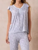 Conjunto de pijama marca René Rofé, compuesto por una remera de escote en V con botones y un pantalón capri con cintura elastizada, ambos en tejido soft estampado con motivos florales en tonos celeste y blanco.