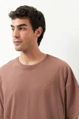 Remerón unisex verde militar de manga corta y cuello redondo, con pequeño estampado lateral en el frente y otro grande en la espalda.