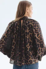Blusa de manga larga oversized con estampado de leopardo, cuello elevado drapeado con frunces y puños anchos con botones forrados.