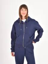 Campera con capucha y cierre frontal completo, confeccionada en tejido de algodón, con bolsillos tipo canguro y puños elásticos.