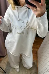 Buzo con capucha de algodón en color beige, con diseño de estampa en letras doradas en la parte frontal y cordones ajustables en el cuello.