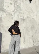 Conjunto deportivo compuesto por un buzo negro de corte cropped con costuras a la vista y un pantalón jogging gris de tiro alto, corte holgado y costuras verticales decorativas.