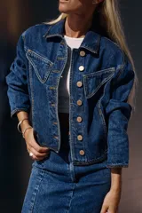 Campera de jean azul con corte vintage y pespuntes en hilo color maíz. Detalles de jean negro en puños, cintura y costados.